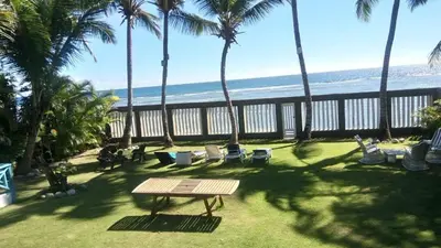 a patio with chairs and a table and the beach at Arena blanca Franchecis hostal in Juan Dolio