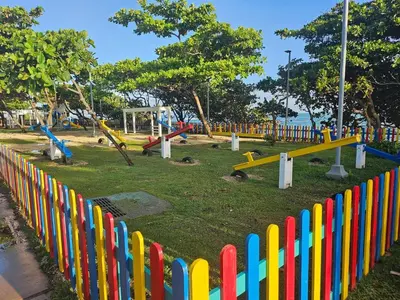 a colorful fence in a park with a playground at Beautiful Oceanfront Apartment Private Balcony in San Felipe de Puerto Plata