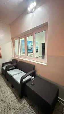 a room with two black couches and two windows at Beautiful Oceanfront Apartment Private Balcony in San Felipe de Puerto Plata