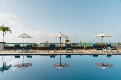a swimming pool with chairs and umbrellas at Catalonia Santo Domingo in Santo Domingo