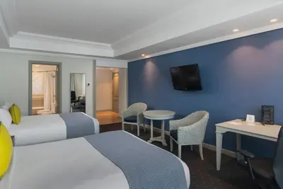 a hotel room with a bed and a table and chairs at Catalonia Santo Domingo in Santo Domingo