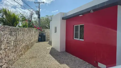 a red and white building next to a stone wall at Wohlfühloase in der Karibik in Punta Cana