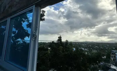 a window with a view of a city at Comodidad, descanso y una vista que inspira in Miches