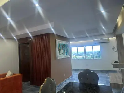a living room with two chairs and a ceiling with lights at Comodidad, descanso y una vista que inspira in Miches