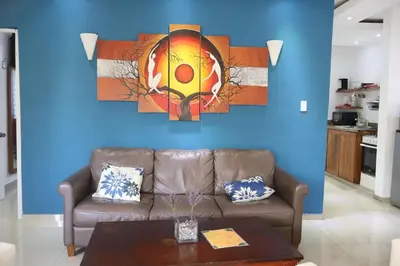 a living room with a couch and a blue wall at Cozy apartment AC, Hot Water, WiFi, Pool, Bar, Bani 203 in Baní