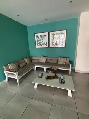 a living room with a couch and a table at 1-Bedroom Apartment Balcony, Gym, Pool & BBQ in Santo Domingo