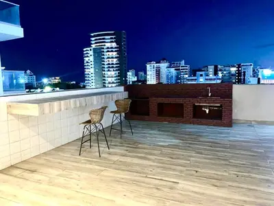 two chairs on the roof of a building with a city skyline at 1-Bedroom Apartment Balcony, Gym, Pool & BBQ in Santo Domingo