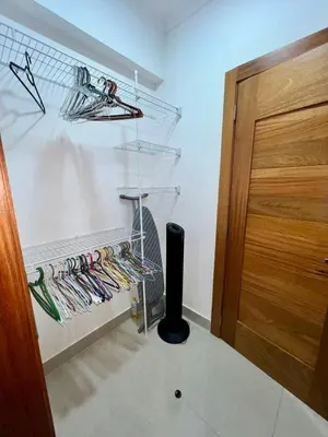 a room with a closet with a rack and a door at 1-Bedroom Apartment Balcony, Gym, Pool & BBQ in Santo Domingo