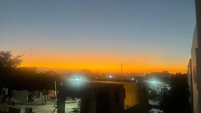 a sunset in a city with street lights and buildings at Charming 2-Bedroom Apartment with Stunning Views in Santiago in Santiago de los Caballeros