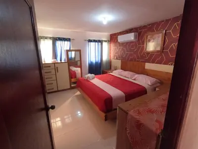 a bedroom with a bed with a red and white blanket at Charming 2-Bedroom Apartment with Stunning Views in Santiago in Santiago de los Caballeros