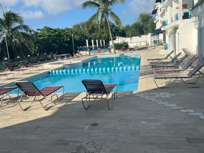 a group of chairs sitting around a swimming pool at Dreamvillage in Boca Chica