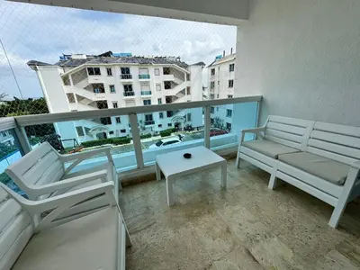 a balcony with chairs and a table and a view of a building at Dreamvillage in Boca Chica