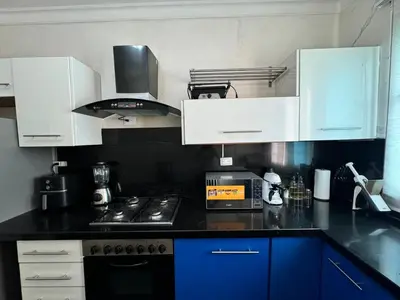 a kitchen with white cabinets and a black counter top at Dreamvillage in Boca Chica