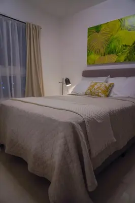 a bedroom with a large bed with a large painting on the wall at Best Loft In The Heart of Santo Domingo Este in Juan López