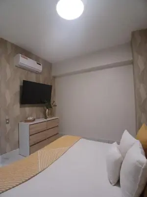 a bedroom with a bed with a tv on the wall at Downtown, Cozy and Modern! in Santo Domingo