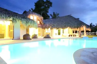 a swimming pool in front of a house at night at Grandi spazi vista mare piscina infinity con grotta taina in Las Terrenas