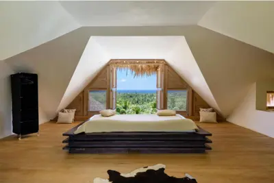 a bedroom with a bed with a large window at Grandi spazi vista mare piscina infinity con grotta taina in Las Terrenas