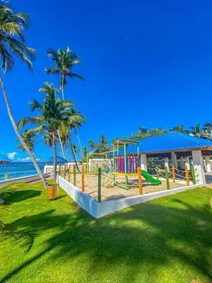 a playground on a beach with palm trees at Beach Front Condo!