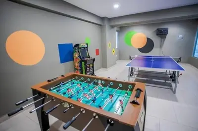 a ping pong table in a room with a pool at Beach Front Condo!