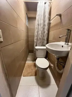 a small bathroom with a toilet and a sink at Mirador de las Nubes in Jarabacoa