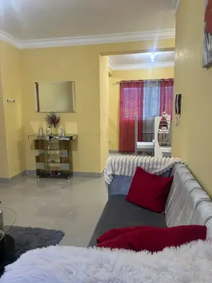 a living room with a gray couch with red pillows at Garden view paradise in Concepción de La Vega