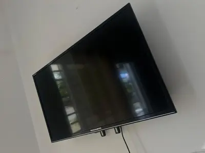 a flat screen tv hanging on a wall at Residencial Larimar 1 - Steps from Bayahíbe Beach in Bayahibe