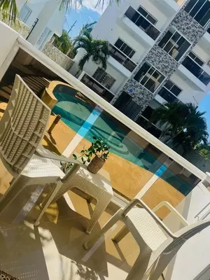 a balcony with a table and chairs and a swimming pool at Residencial Larimar 1 - Steps from Bayahíbe Beach in Bayahibe