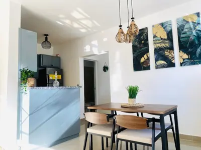 a kitchen and dining room with a wooden table and chairs at Residencial Larimar 1 - Steps from Bayahíbe Beach in Bayahibe