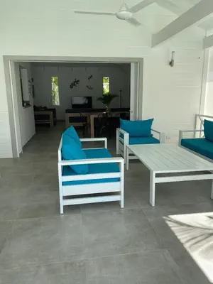 a living room with blue chairs and a table at Villa Exceptional location - Las Ballenas in Las Terrenas