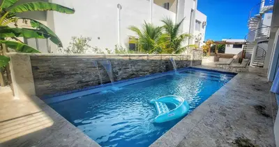 a swimming pool with a slide in the middle at Villa Jasmine Ocean Village in Sosúa