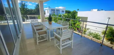 a porch with a table and chairs on a balcony at Apt Jasmine Ocean Village in Sosúa
