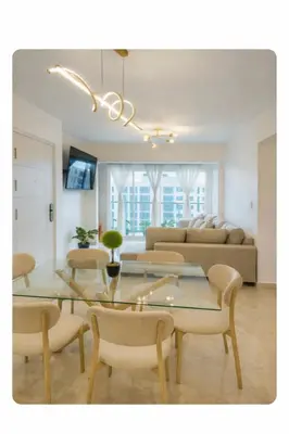 a living room with a table and chairs at Apartamento cerca del aeropuerto y la playa in San Isidro