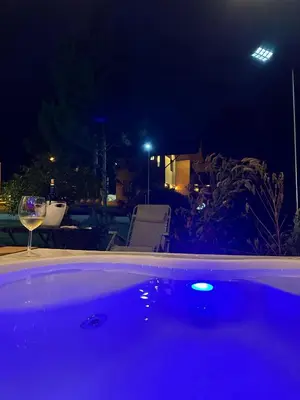 a bath tub with a glass of wine at night at La Gloria in San José de Ocoa