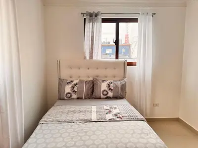 a bed in a room with a window at Enjoy Huge 4 bedrooms and 3 bathrooms in Santiago de los Caballeros