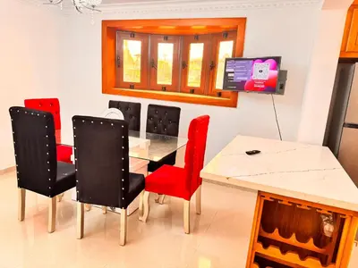 a dining room with a table and red chairs at Enjoy Huge 4 bedrooms and 3 bathrooms in Santiago de los Caballeros