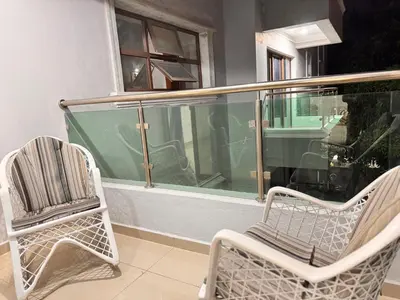 two chairs and a window on a balcony at NEW 8apts enjoy HUGE 4 bedrs in Santiago de los Caballeros