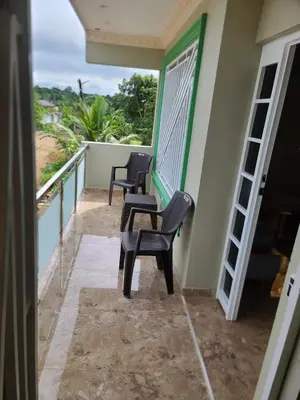 a balcony of a house with two chairs and a table at Apartahotel Henry Winche in Sabana Grande de Boyá