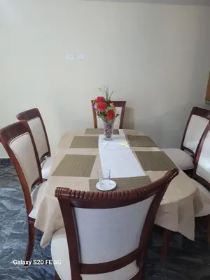 a table with chairs and a vase of flowers on it at bienvenido a casa in San Pedro de Macorís