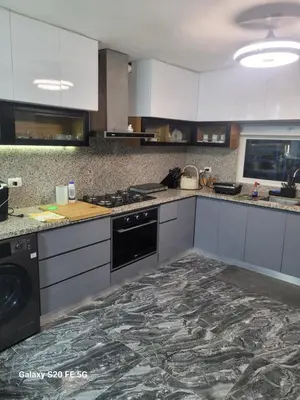 a kitchen with white cabinets and a black appliance at bienvenido a casa in San Pedro de Macorís