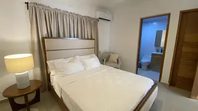 a bedroom with a bed and a table with a lamp at Apartamento San Pedro Colonial in San Pedro de Macorís