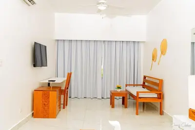 a living room with a table and chairs and a television at Hotel Stars Bávaro hab 102 in Punta Cana