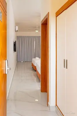 a hallway with two beds and a door to a room at Hotel Stars Bávaro hab 102 in Punta Cana
