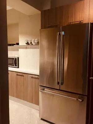 a stainless steel refrigerator in a kitchen with wooden cabinets at MarMary Ocean view by Marina in Boca Chica