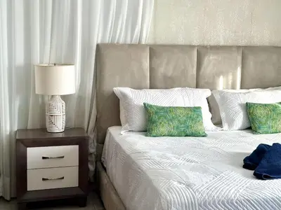 a bedroom with a bed and a nightstand with a lamp at Soha Suites II Deluxe in Colorado
