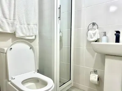 a white bathroom with a toilet and a sink at Mini Hogar Céntrico in Santiago de los Caballeros