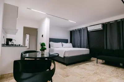 a bedroom with a bed and a glass table at Arena Aparta Hotel in Punta Cana