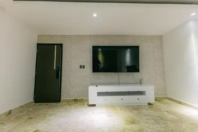 a living room with a tv on a wall at Arena Aparta Hotel in Punta Cana