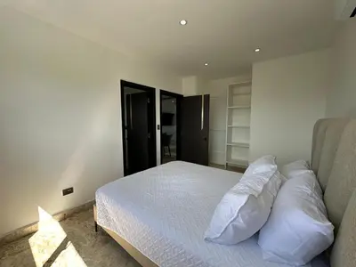 a bedroom with a bed with white sheets and pillows at Arena Aparta Hotel in Punta Cana