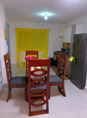 a kitchen with a table and chairs and a refrigerator at Apartamento Alto del valle de 2 habitaciones in Santiago de los Caballeros