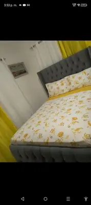 a bed in a room with a bed frame with a bedspread with animals at Apartamento Alto del valle de 2 habitaciones in Santiago de los Caballeros